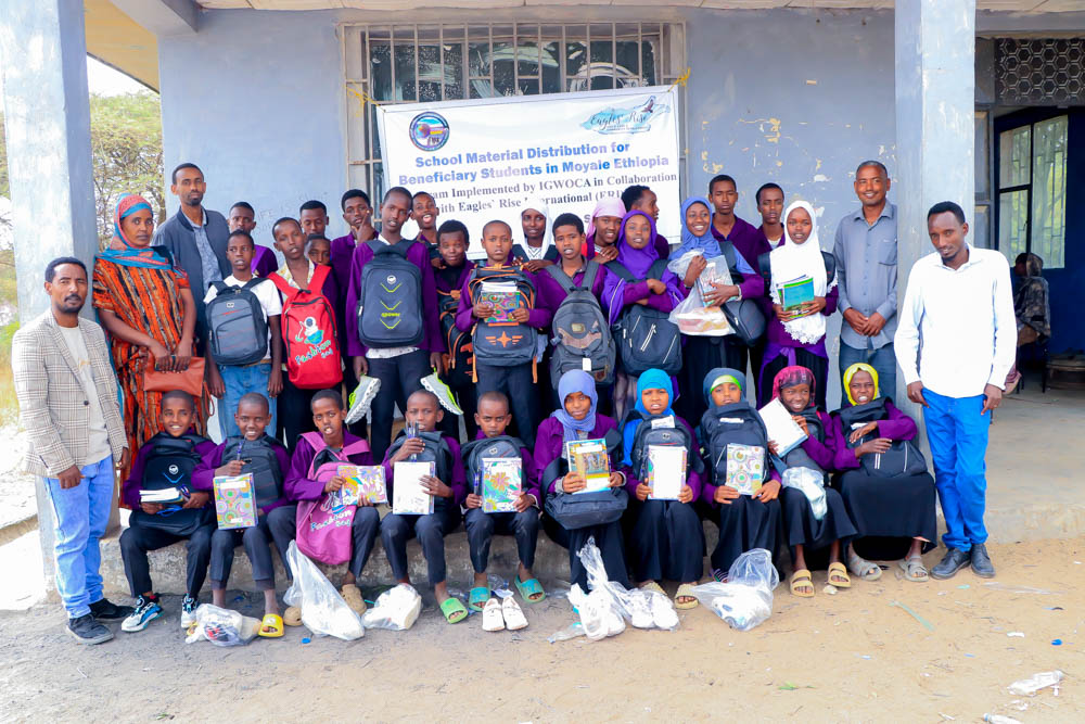 another group of students with supplies in front of school